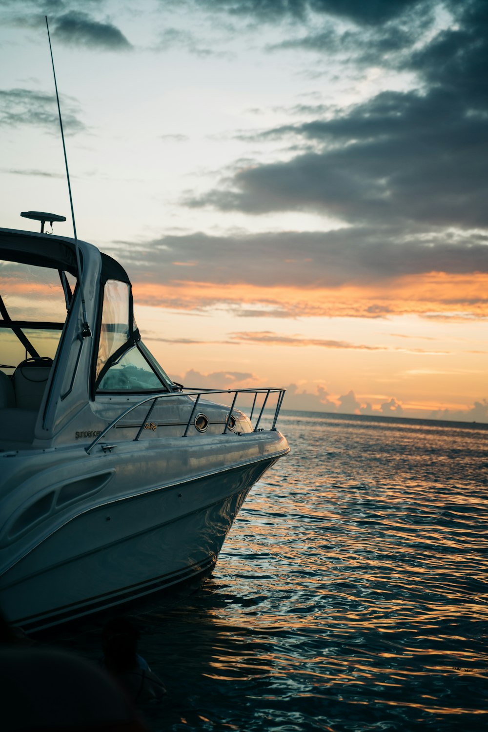 barco branco e azul no mar durante o pôr do sol