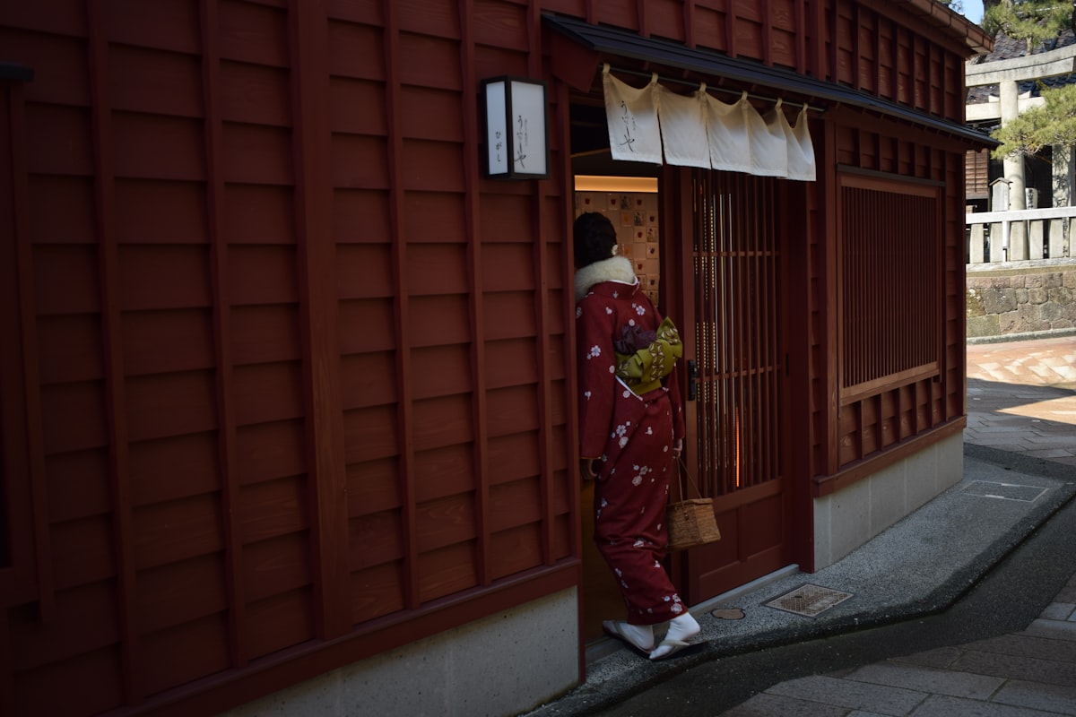 Higashi Chaya Kanazawa — woman in red and yellow kimono standing on the traditional district street