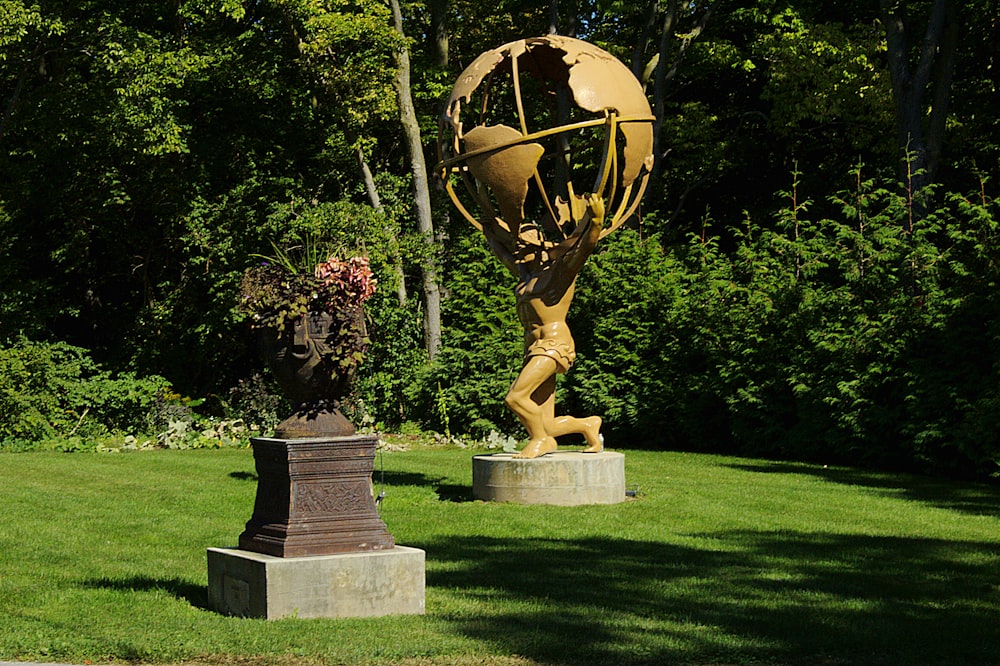 brown concrete statue on green grass field during daytime