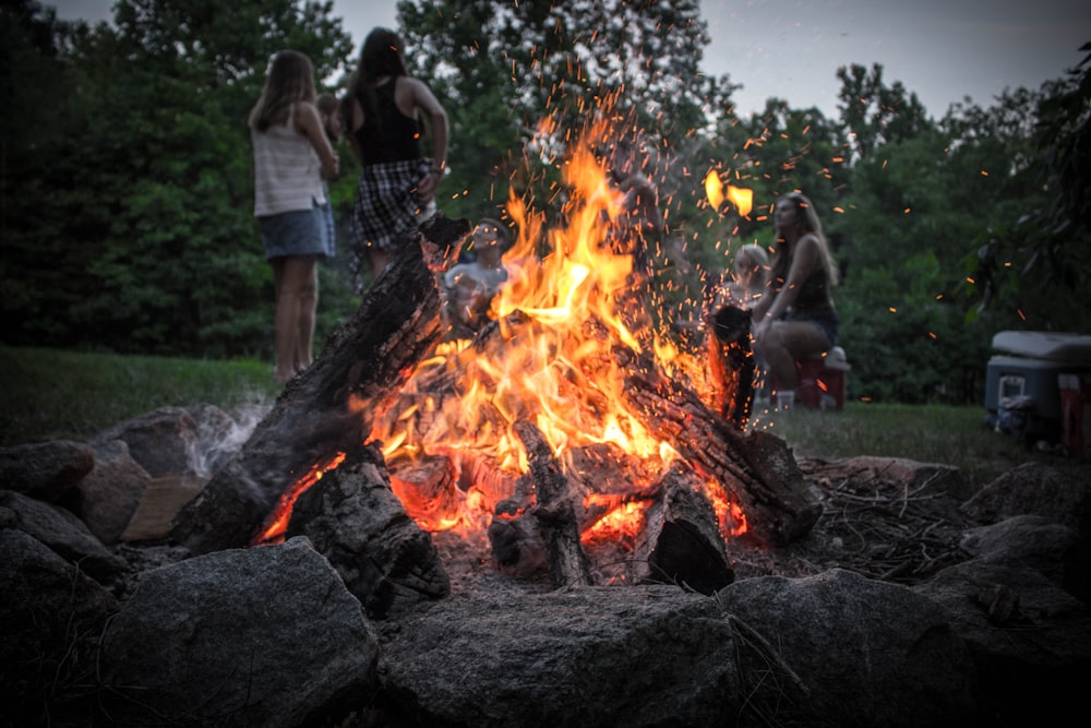 Mann in schwarzem T-Shirt tagsüber in der Nähe des Lagerfeuers