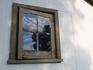 Modern white aluminum window frame with blue sky reflection