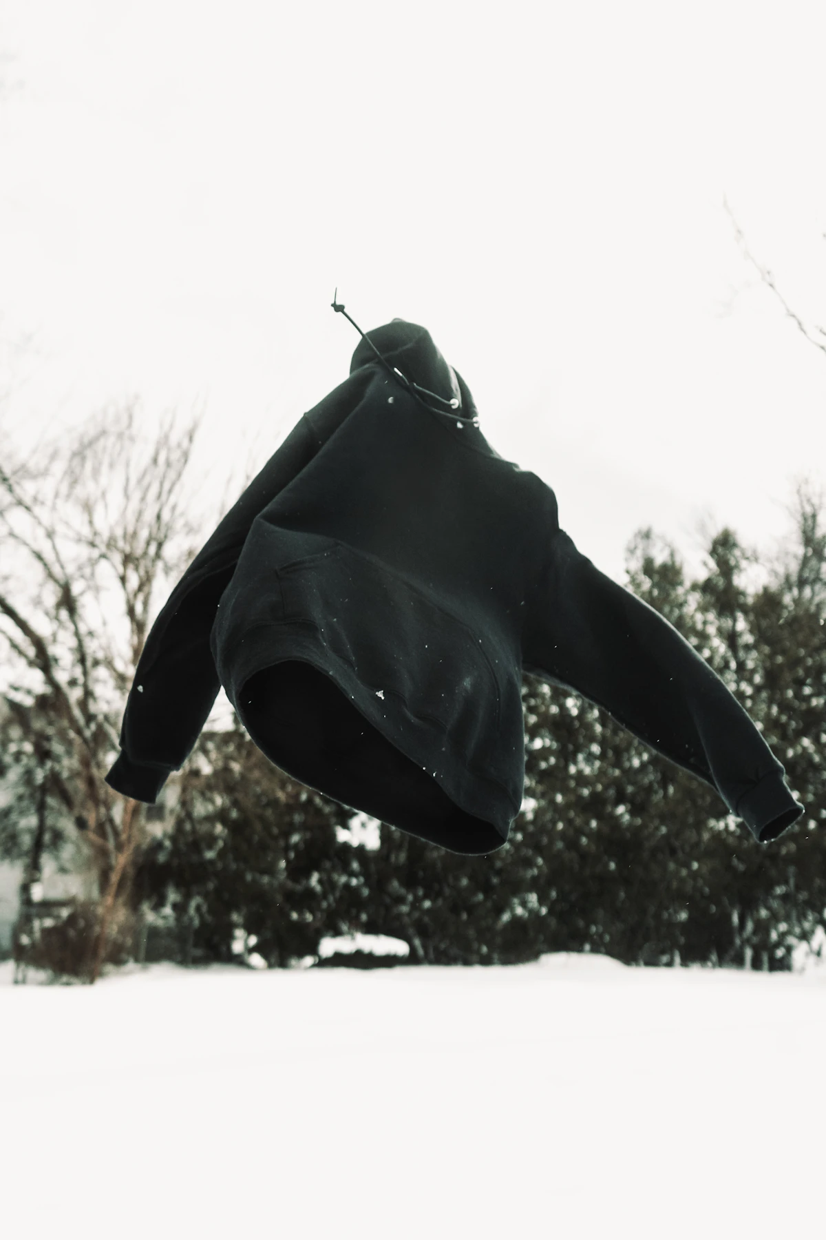 Black hoodie hanging clean — minimal wardrobe aesthetic