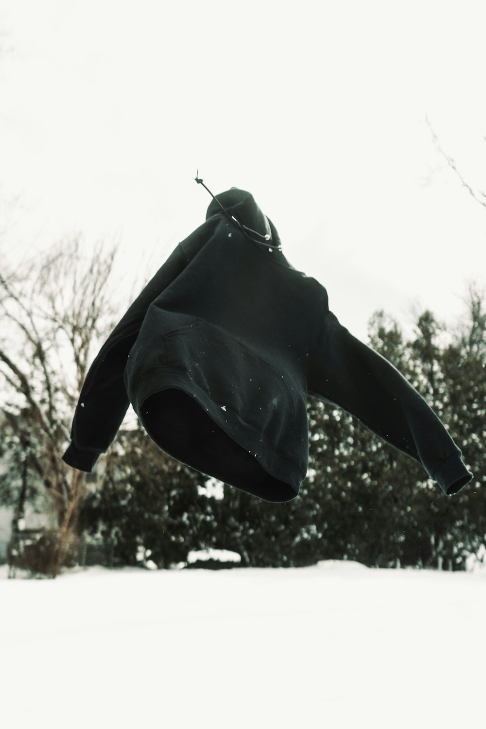 black jacket hanging on rope during daytime