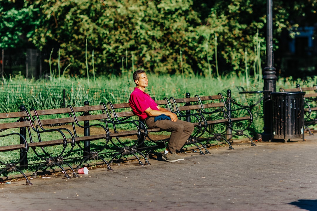 man in red shirt sitting on bench