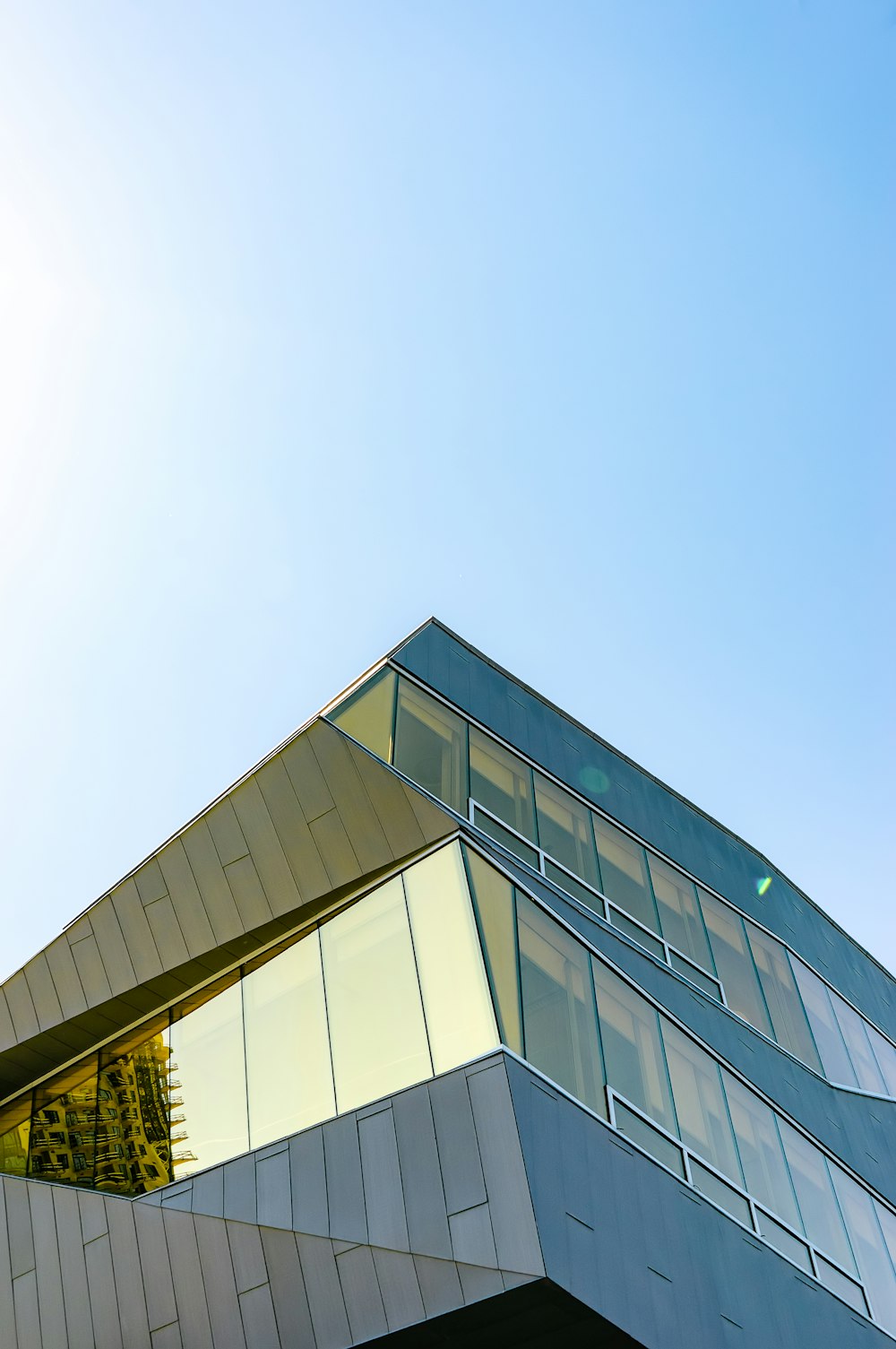 Graues Betongebäude unter blauem Himmel tagsüber