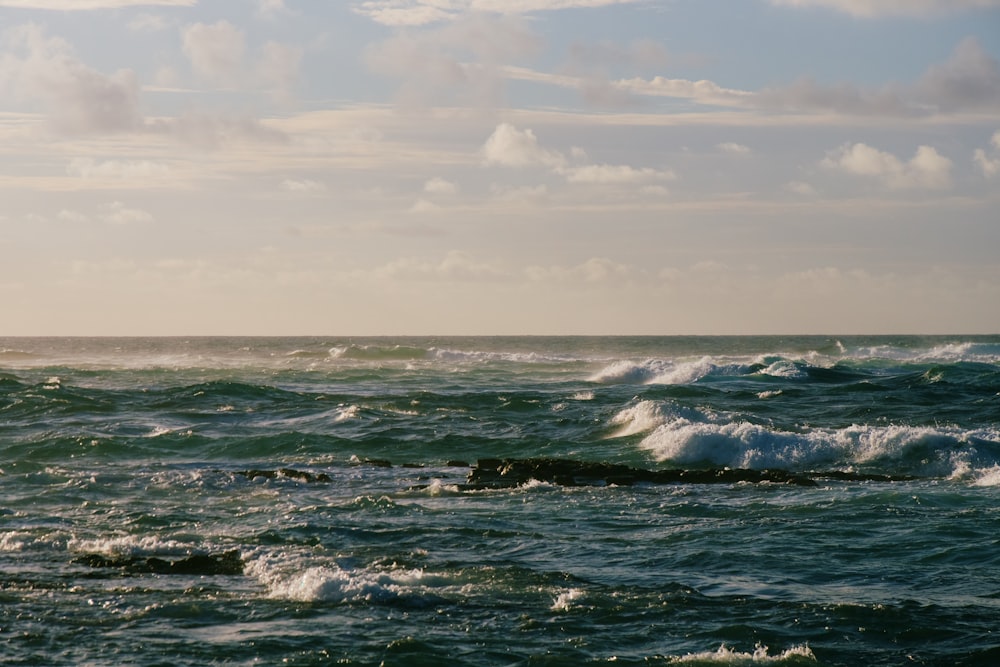 ocean waves under cloudy sky during daytime