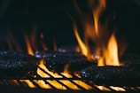 Slow-motion shot of a burger patty hitting the grill with flames rising around it