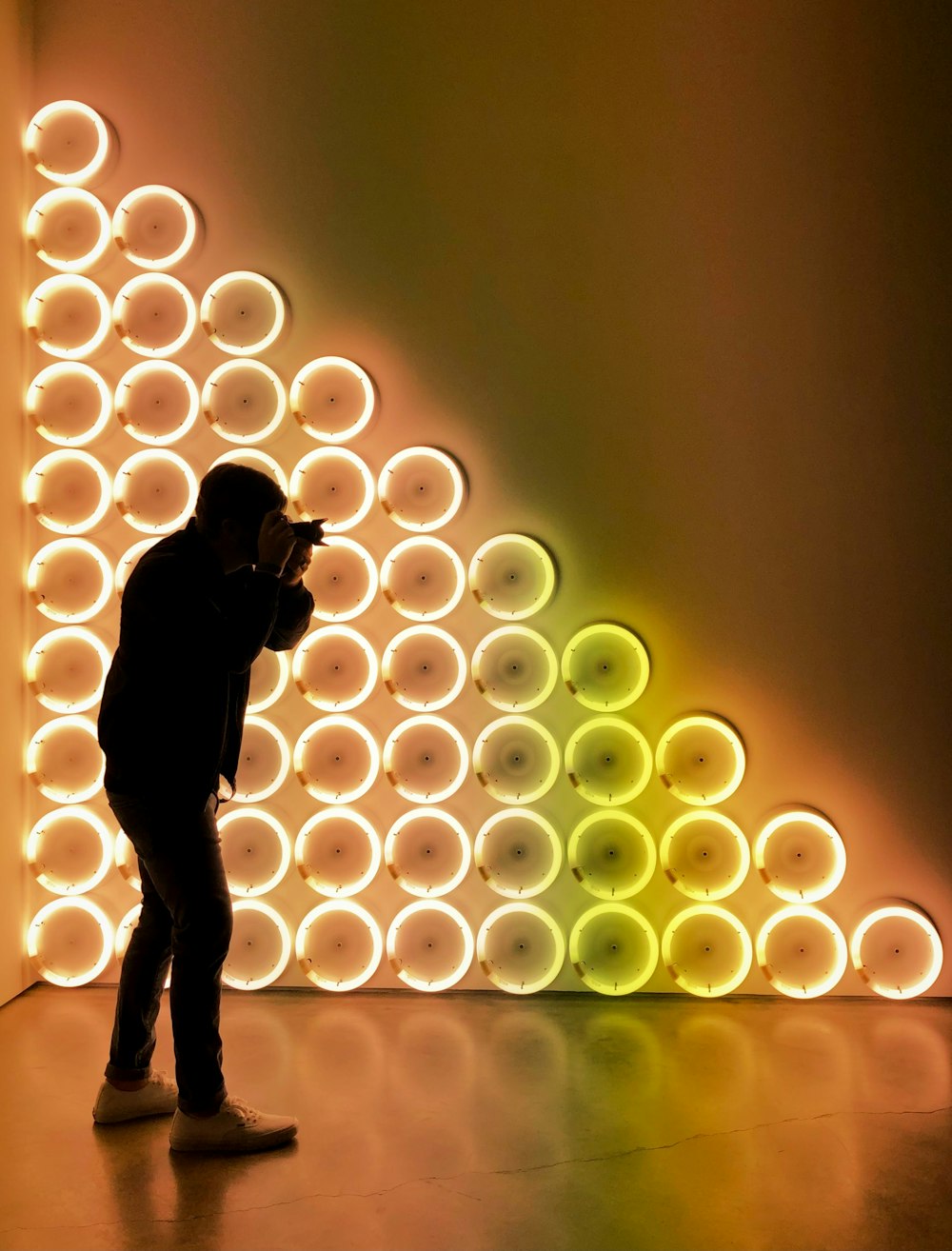 silhouette di donna in piedi davanti al muro illuminato