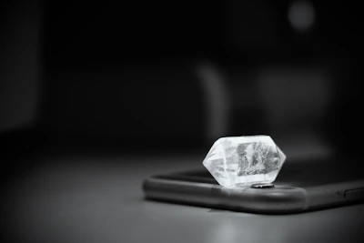 Sleek acrylic phone case reflecting soft light, highlighting its crystal-clear design on a marble surface.