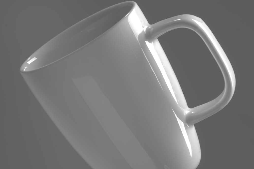 white ceramic mug on white surface