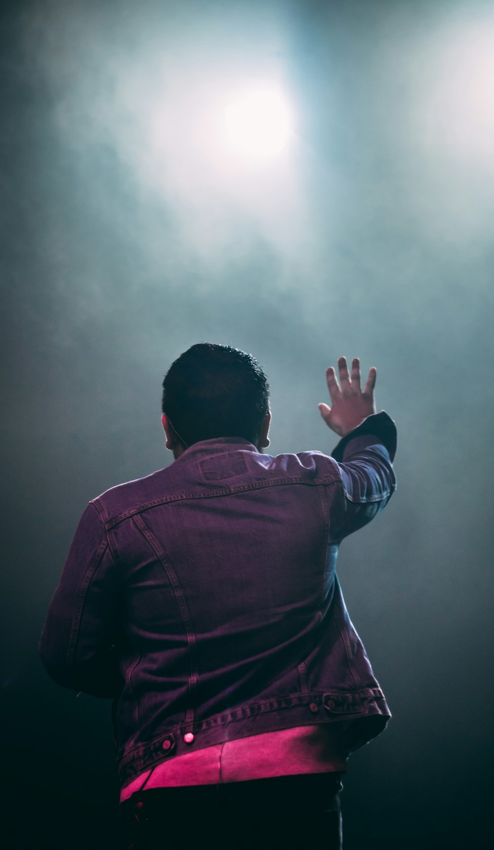 man in red jacket covering his face with his hands