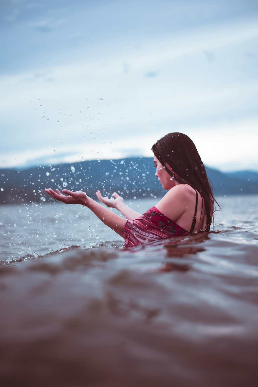 woman in red dress on water during daytime