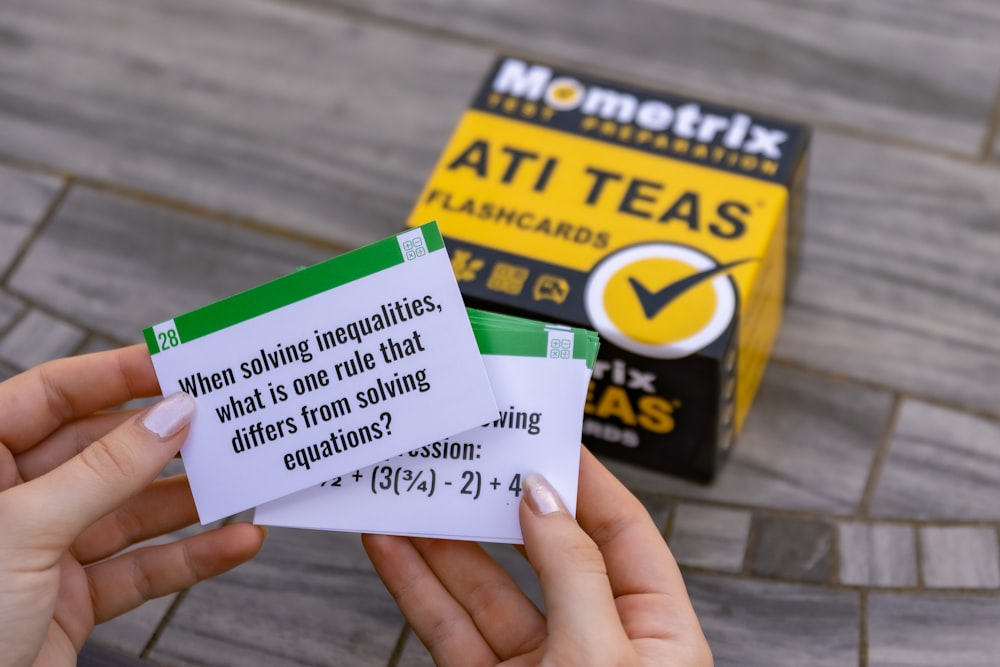 person holding white green and yellow box