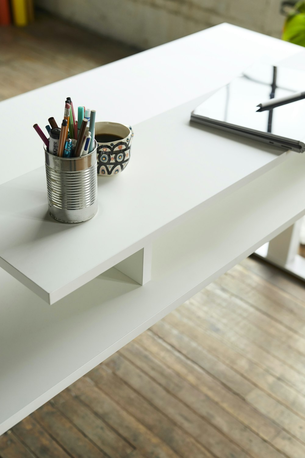 pencils in white steel cup on white wooden table