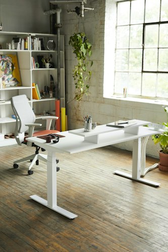 Modern office workspace with an adjustable desk and ergonomic chair