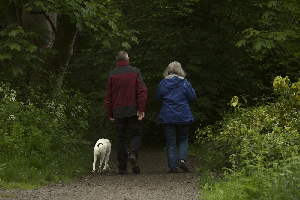 man in red jacket standing beside woman in blue jacket