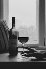 grayscale photography of wine bottle and wine glass