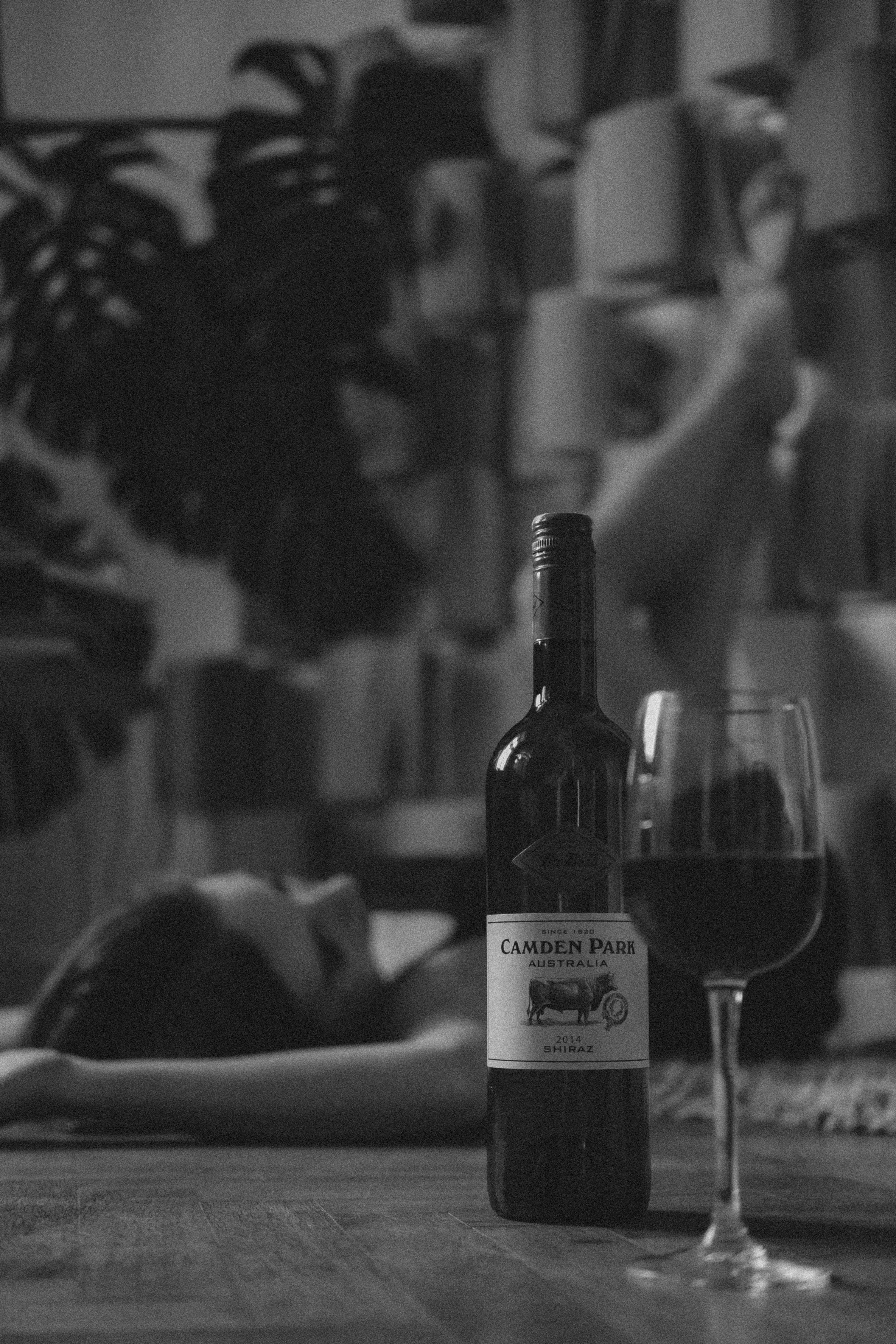 grayscale photo of wine bottle and wine glass