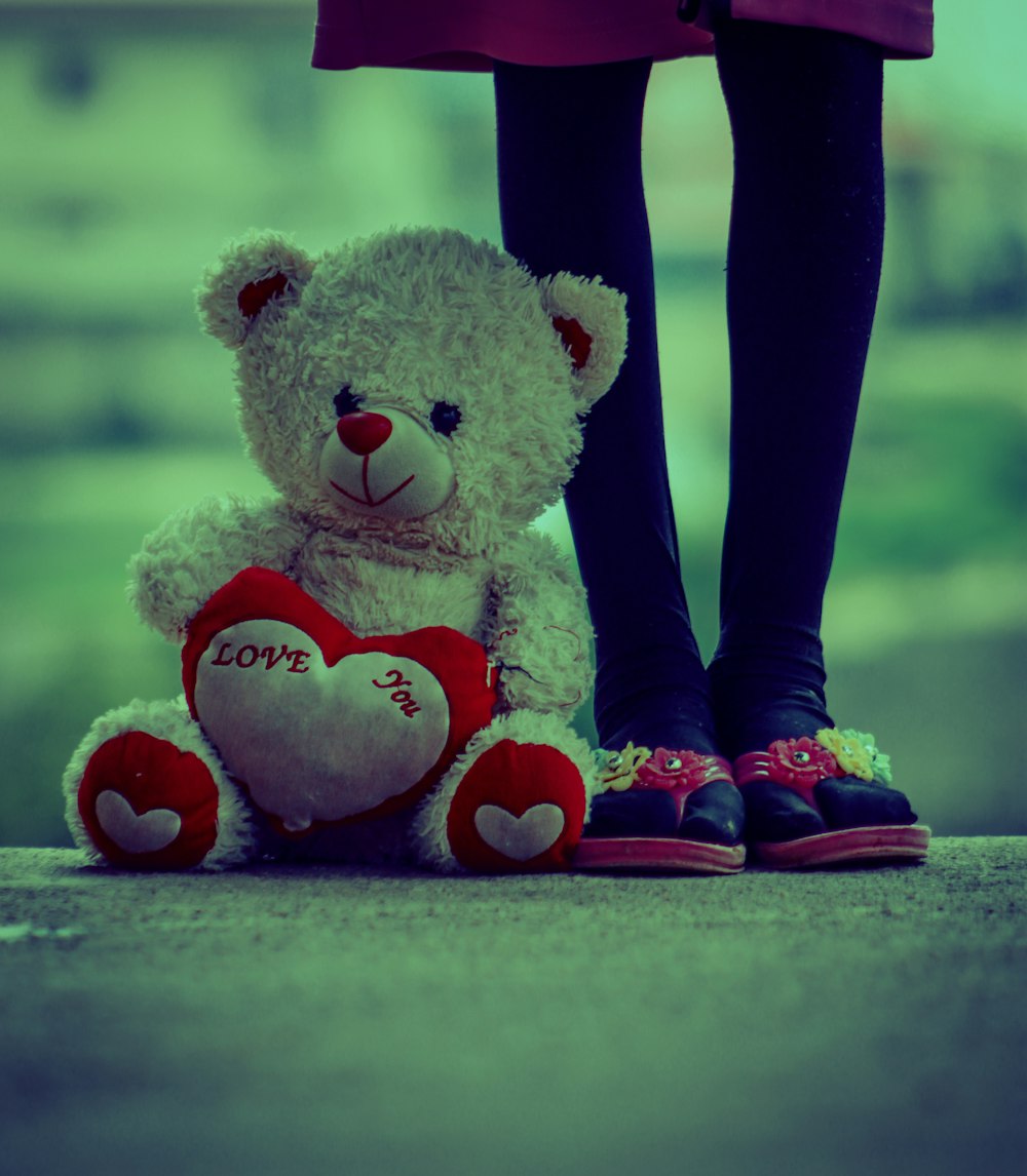 person wearing red and black socks and white bear plush toy