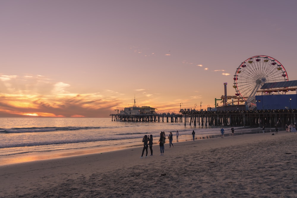 people walking on beach during sunset