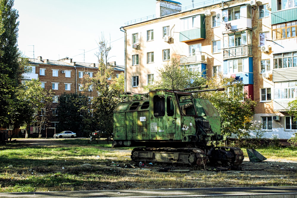 green train on rail road near building during daytime