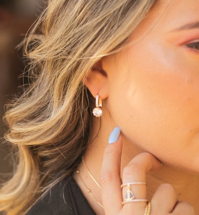 woman wearing silver and diamond stud earring