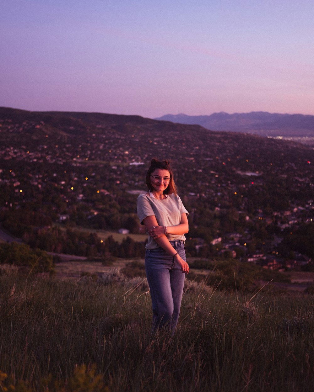 woman in white shirt standing on green grass field during daytime