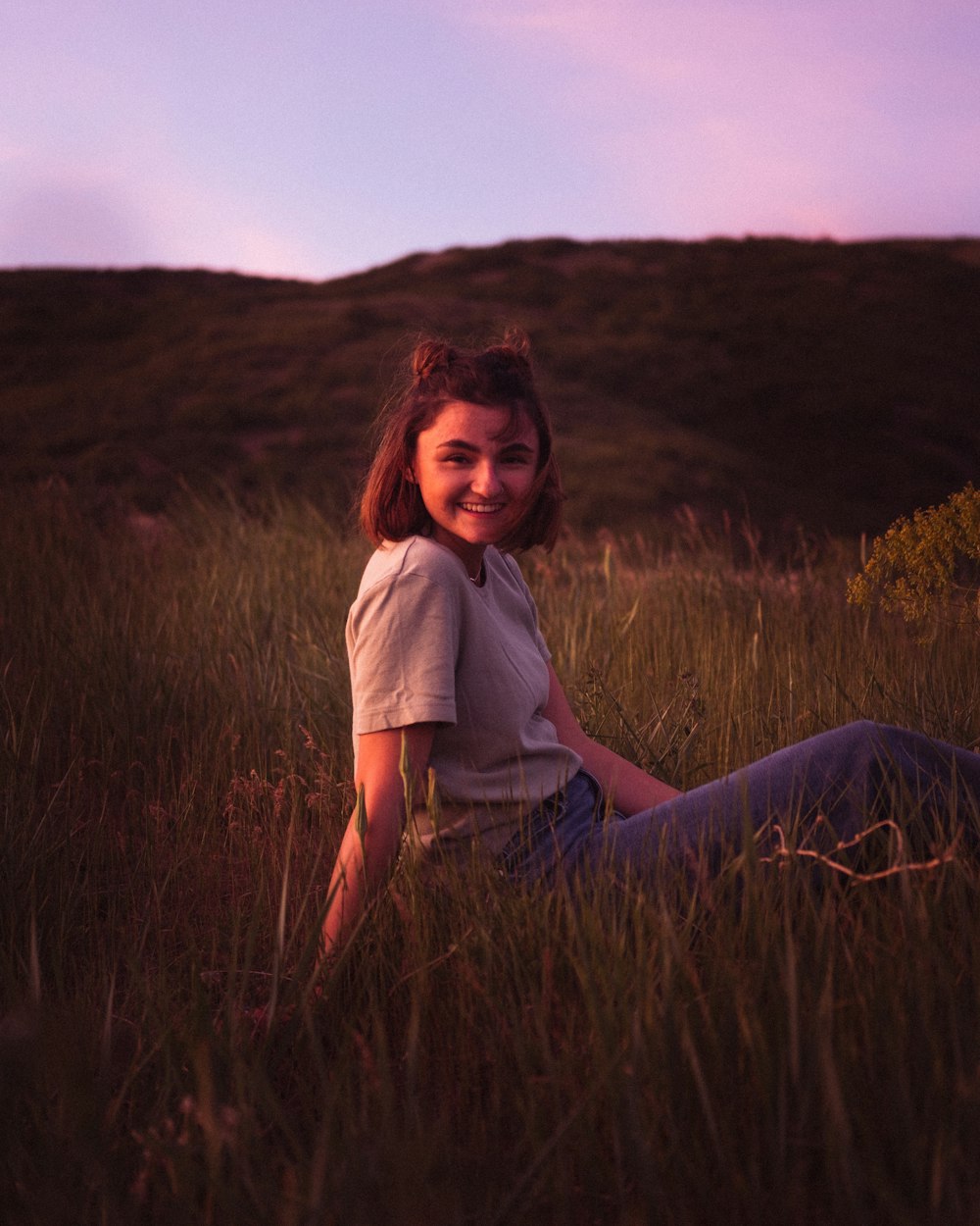 woman in white shirt sitting on grass field