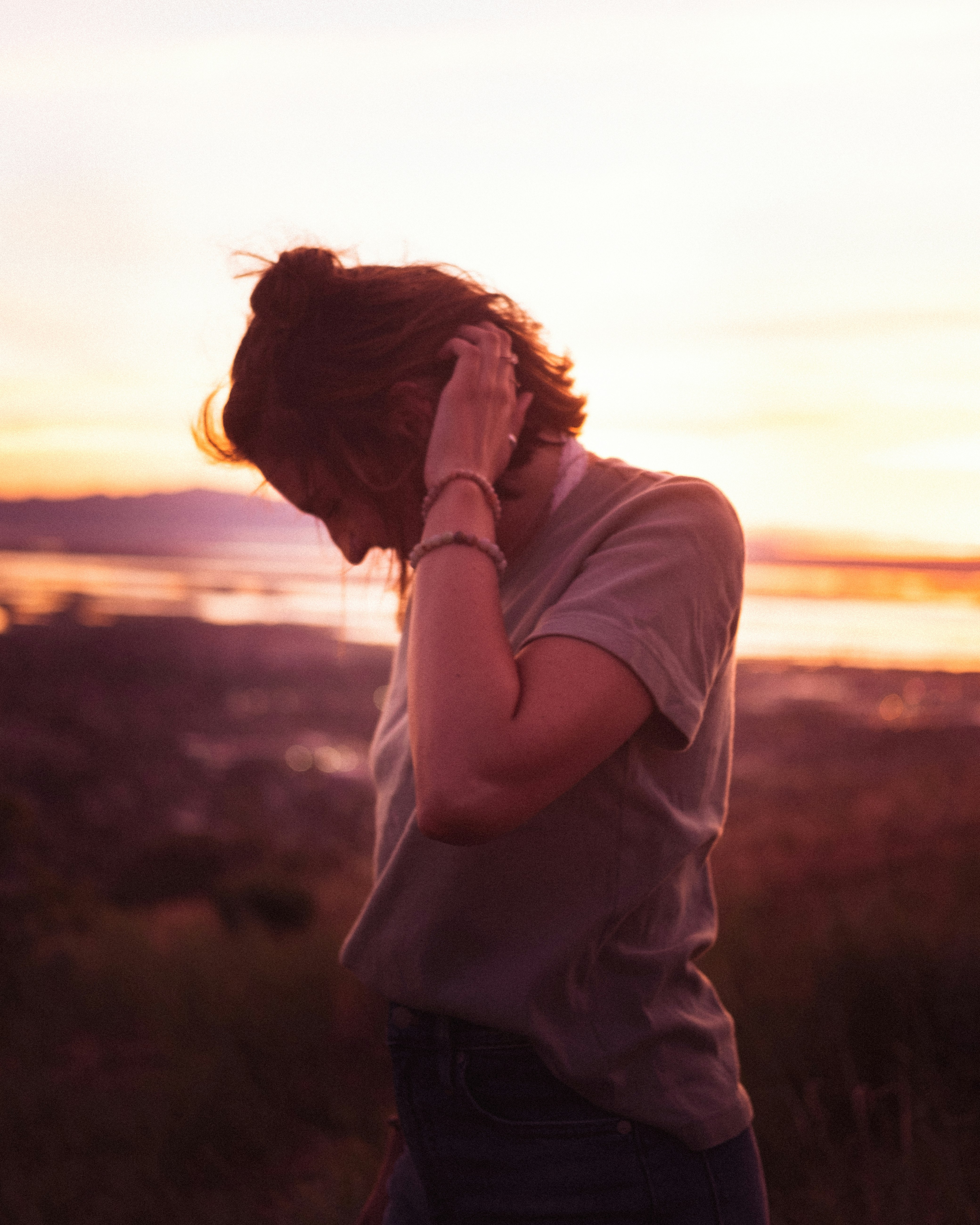 woman in white long sleeve shirt standing on field during sunset