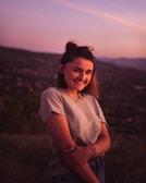Smiling man looking confident and relaxed outdoors during sunset.