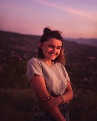 Smiling man looking confident and relaxed outdoors during sunset.