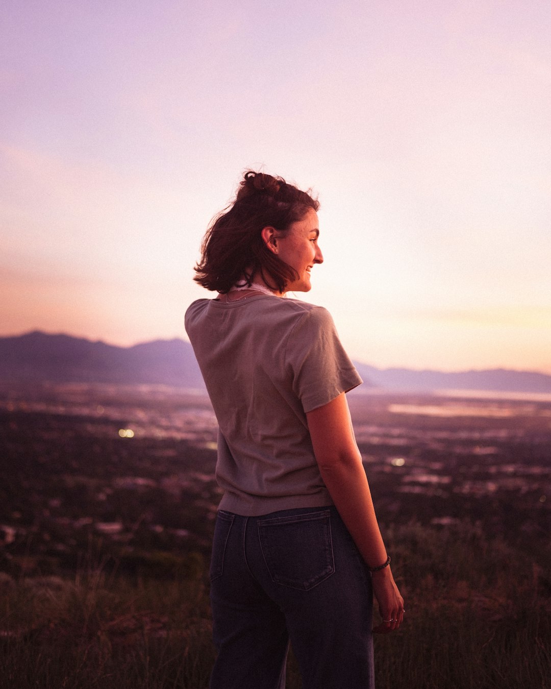 woman in white t-shirt standing on grass field during daytime