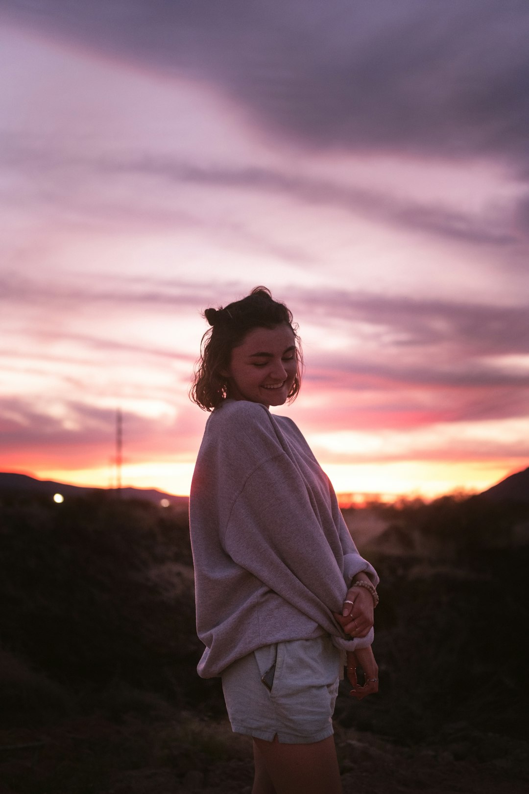 woman in white long sleeve shirt standing on field during sunset