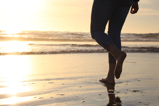 person in black pants standing on beach during daytime