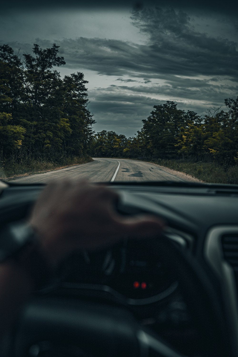 person driving car on road during daytime