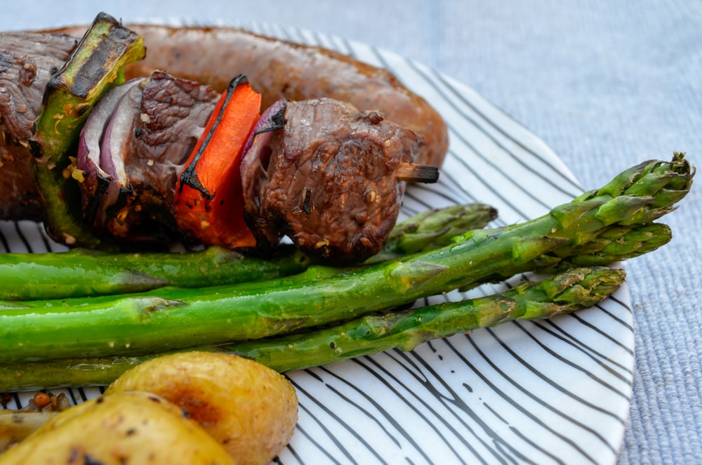 grilled meat with green vegetable on white ceramic plate