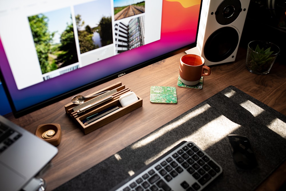 macbook pro beside red ceramic mug