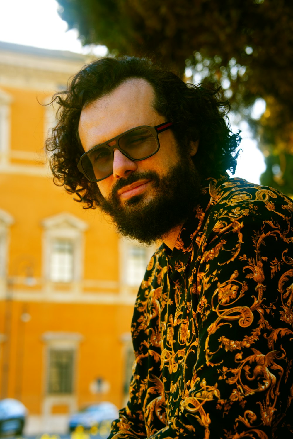 man in black and brown floral shirt wearing black sunglasses