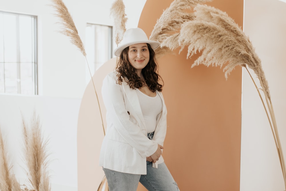 woman in white long sleeve shirt and blue denim jeans wearing white sun hat