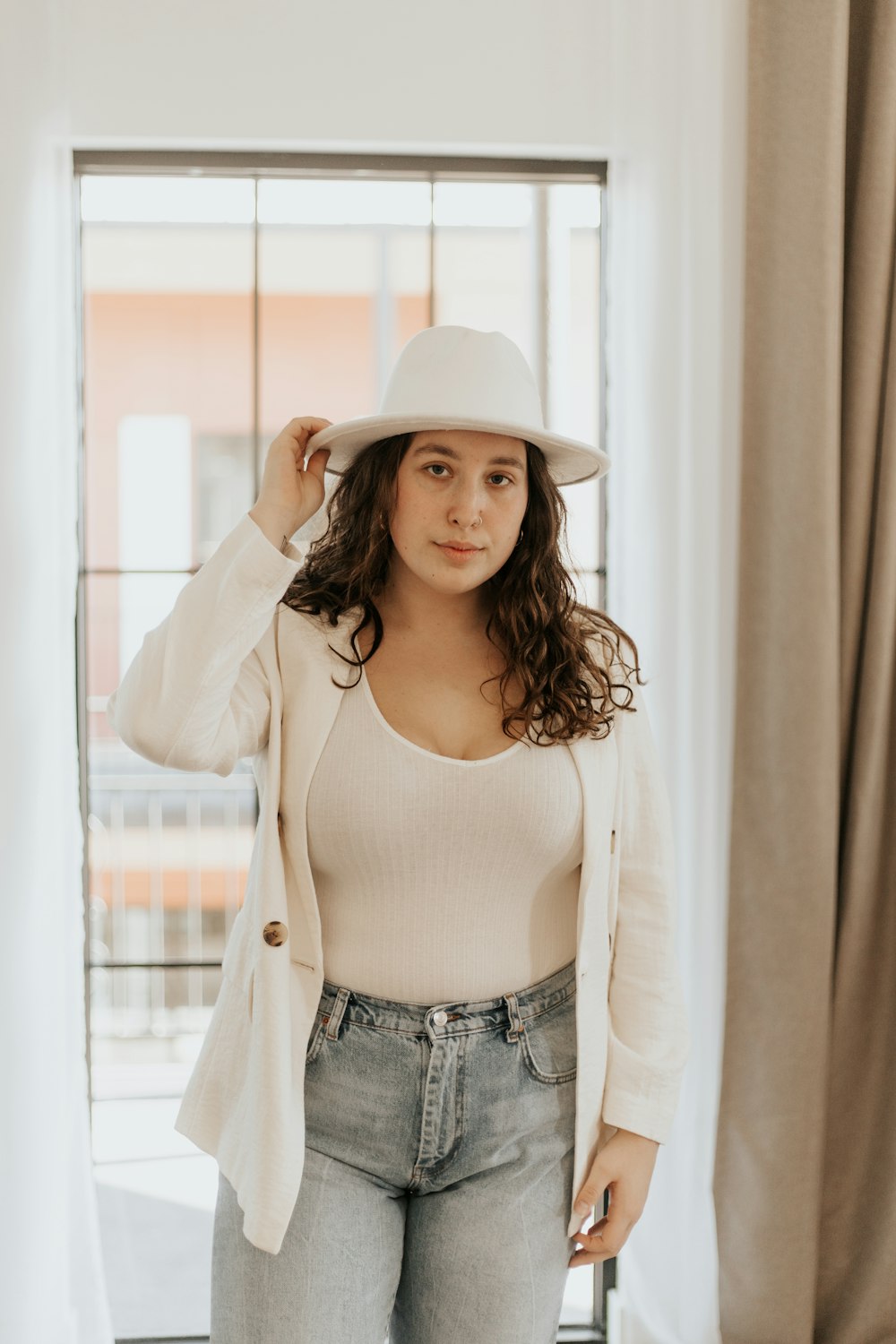 woman in white long sleeve shirt and blue denim jeans wearing white hat