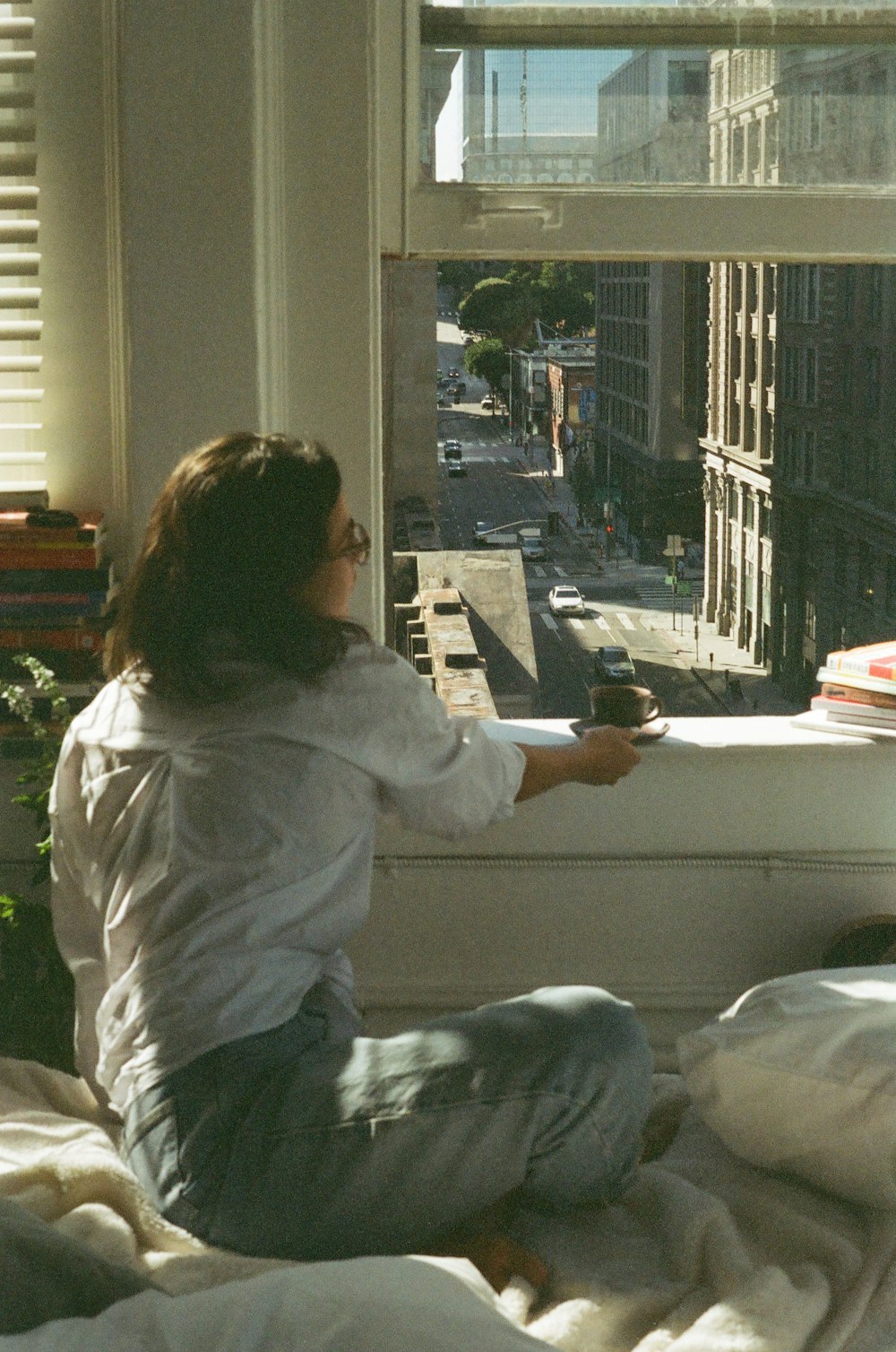 woman in white hoodie sitting on bed