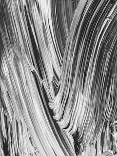 An artistic close-up of textured brush strokes in deep black and gray tones