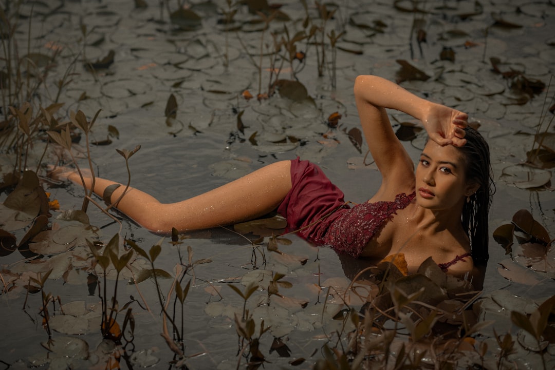 woman in red dress lying on water