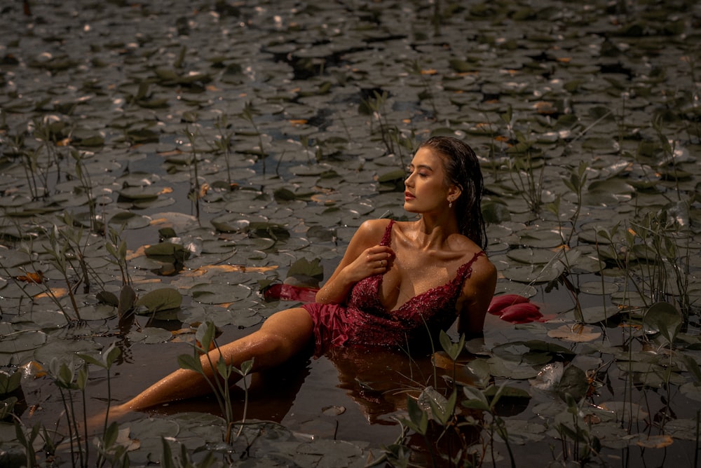 woman in red dress sitting on water