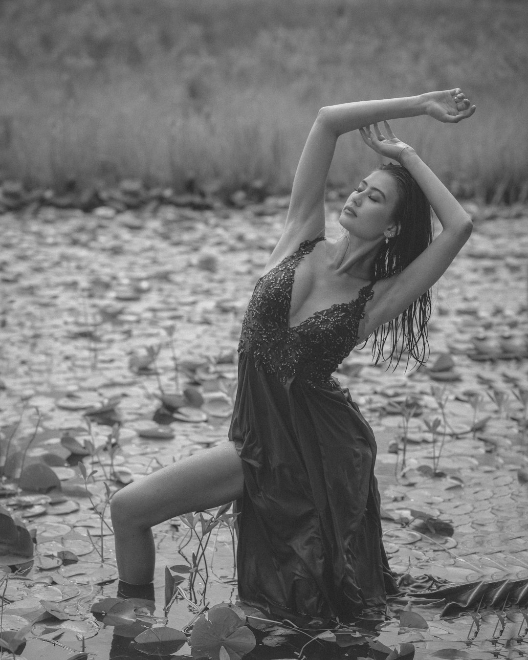 woman in black dress standing on rocky ground