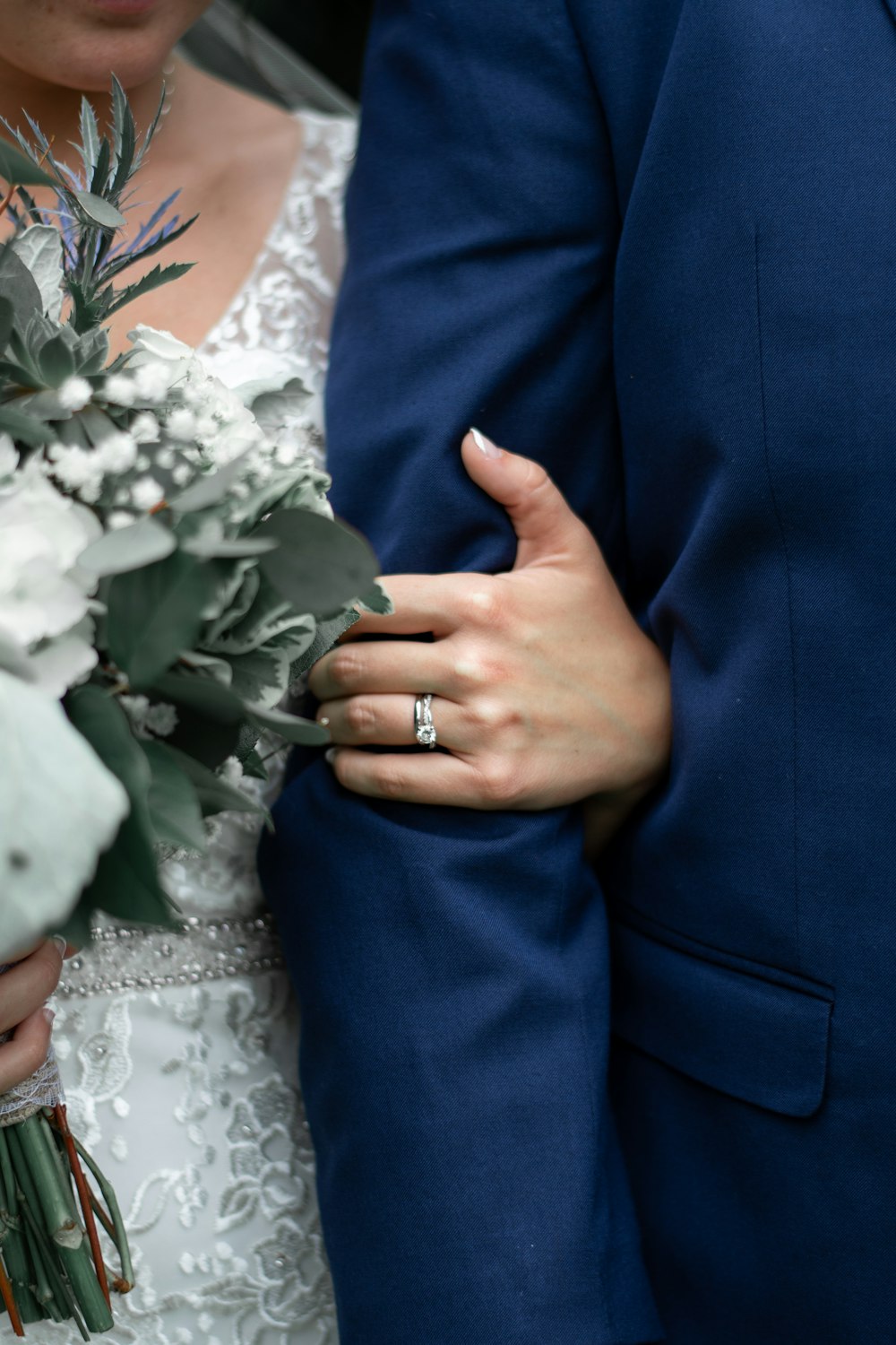 woman in white wedding dress holding white flower bouquet