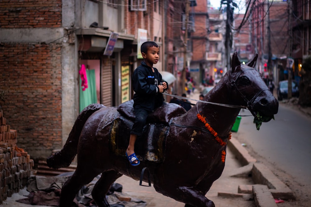 man in black leather jacket riding black horse during daytime