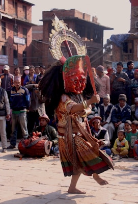 people in red and gold mask dancing on street during daytime