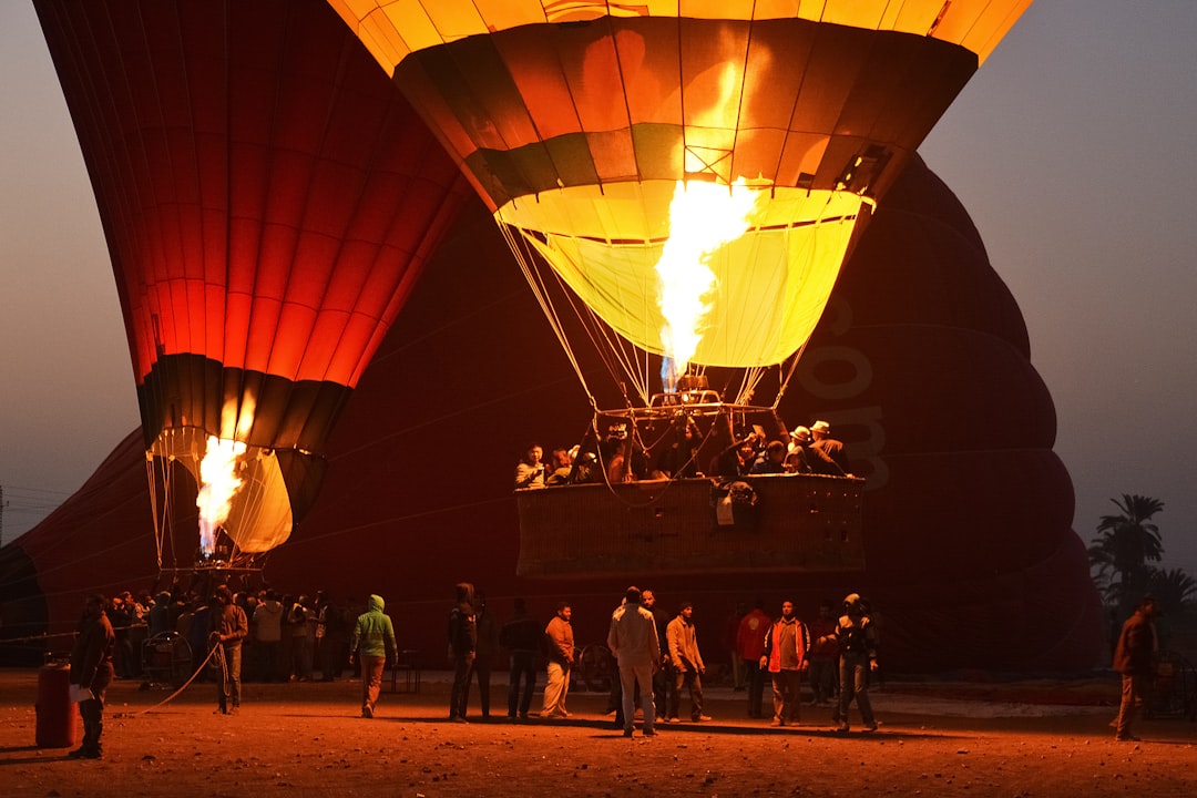 people standing near hot air balloons during night time