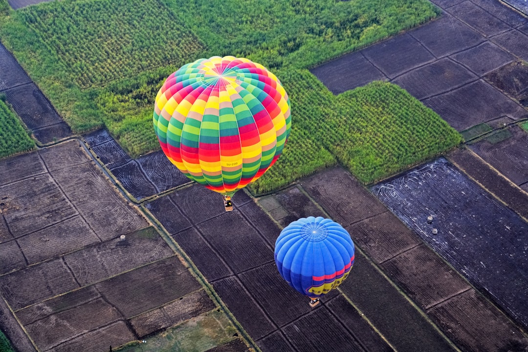 green yellow blue and pink hot air balloon on green grass field